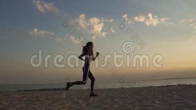 20岁的女孩在日落时在沙滩上奔跑。 在户外慢跑。